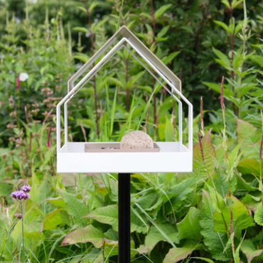 Heeej the Barn vogelhuis wit-zand van voren bekeken in een wilderige tuin