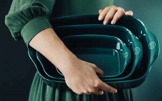 Blog Housewarming cadeau kopen, vrouw met ovenschalen en feestelijke kleding
