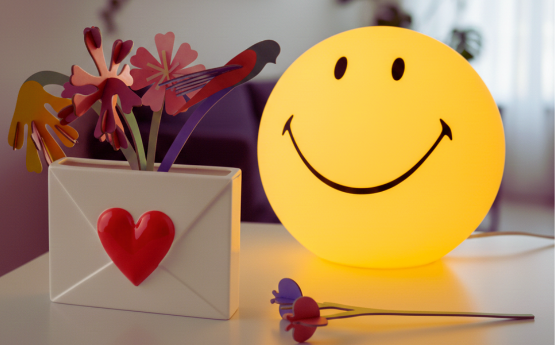 Smiley lamp op tafel met envelopvaas van Fluid Market en Studio Roof bloemen er in 