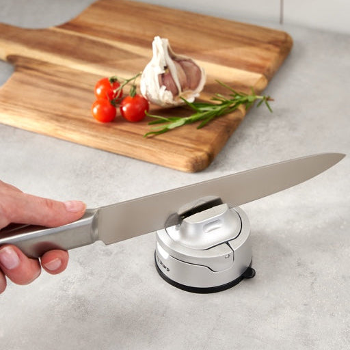 AnySharp Evo Messenslijper - Zilver met mes in slijper op aanrechte met  plank