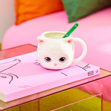 Mok kat met lepeltje op tafel – speels design