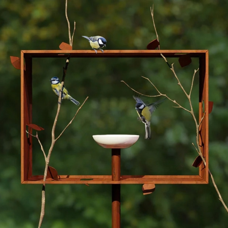 Vogels bij de Frederik Roijé Framed Feeder, een vogelvoederhuis van cortenstaal in de tuin