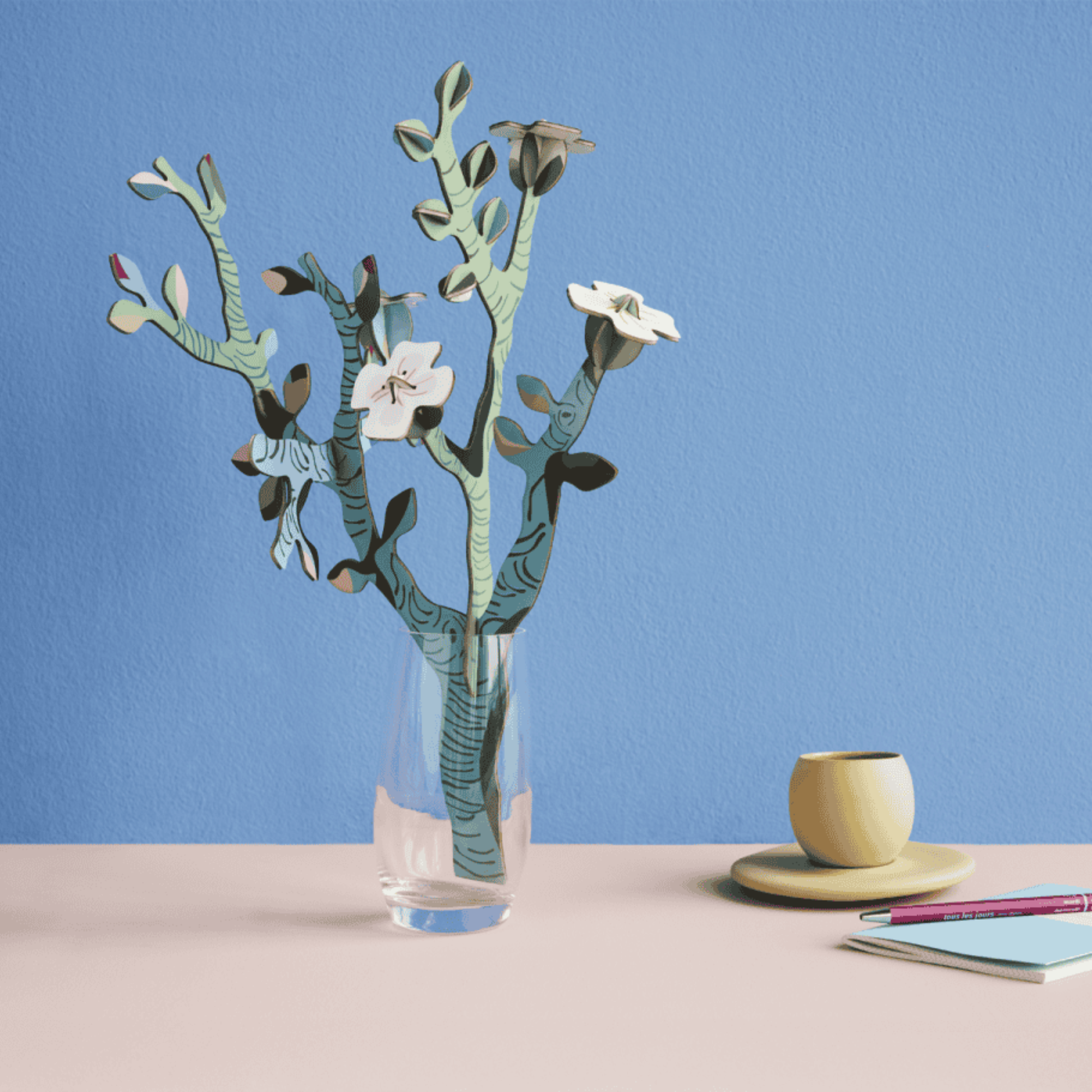 Papieren amandelbloesem boeket van Studio ROOF als kunstzinnige decoratie op een lichte tafel.