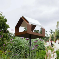 Hey! Das Scheunen-Vogelhäuschen, braun mit weißen Akzenten, steht auf einer Stange.